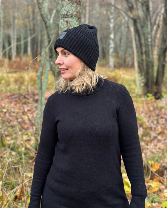 Kvinna i profil med Midvinterglöd-mössan, som visar mössans form från sidan.